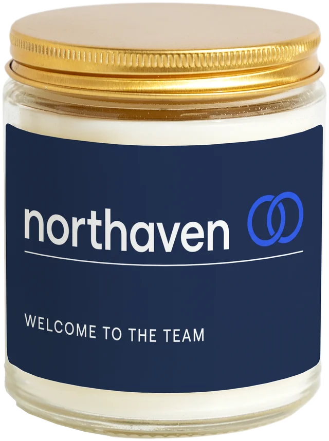 A 9 oz candle jar with a sample New hire welcome gifts label