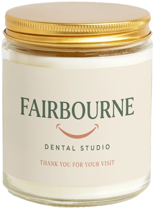 A 9 oz candle jar with a sample New patient welcome gifts label
