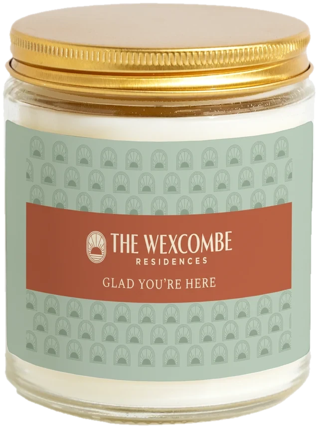 A 9 oz candle jar with a sample Resident move-in gifts label