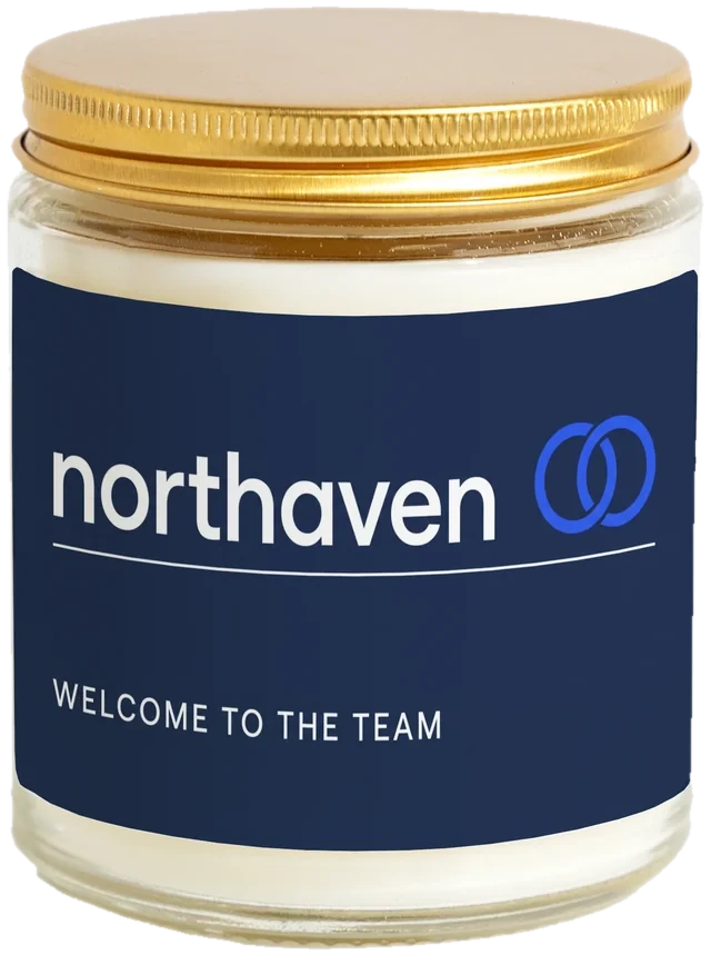 A 9 oz candle jar with a sample New hire welcome gifts label