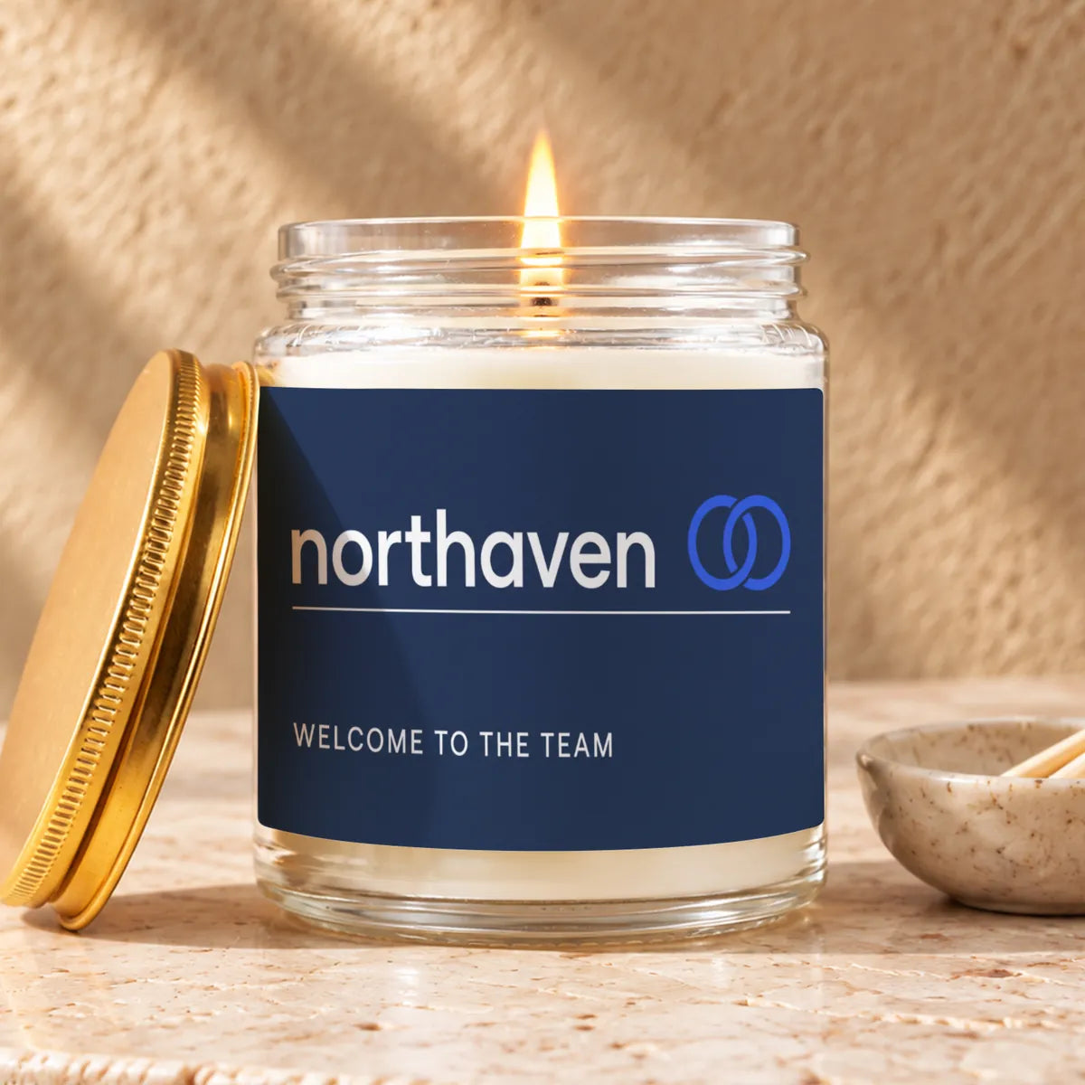 A lit 9 oz Maren Wells jar with a customer's navy label